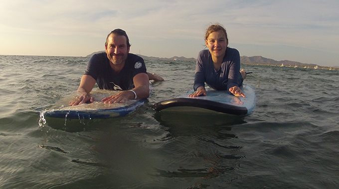 Author Jim Benning and his daughter on surfboards in Tamarindo, Costa Rica.